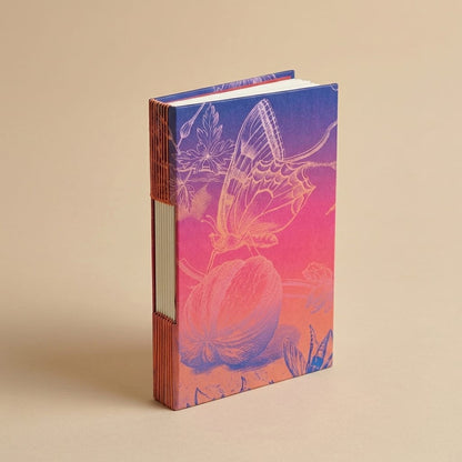 Libreta Bichos con costura ojal y pasta dura con un grabado de mariposa en degradado azul y rosa