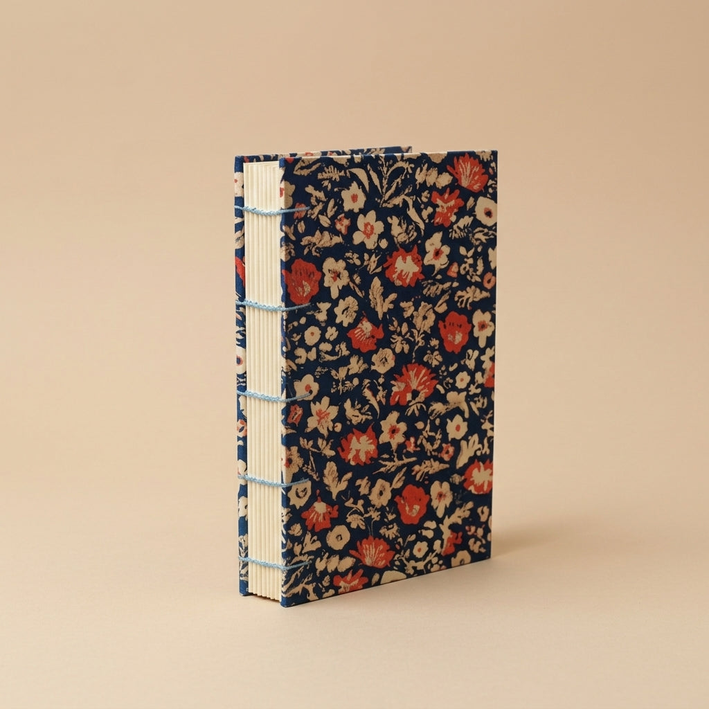 Libreta Matilda con costura copta y pasta dura con flores rojas sobre azul marino